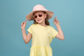 Jolie petite fille portant un chapeau et des lunettes de soleil