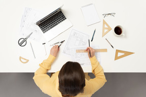 A female architect working on architectural drawings