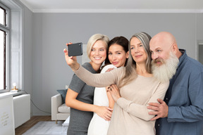 A group of people taking a picture with a cell phone