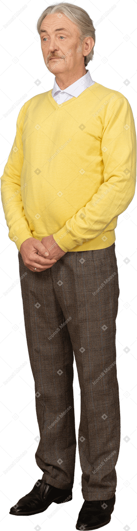 Vista di tre quarti di un vecchio confuso che tiene le mani insieme e indossa un pullover giallo