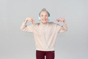 Joyful young lady in headphones dancing to music