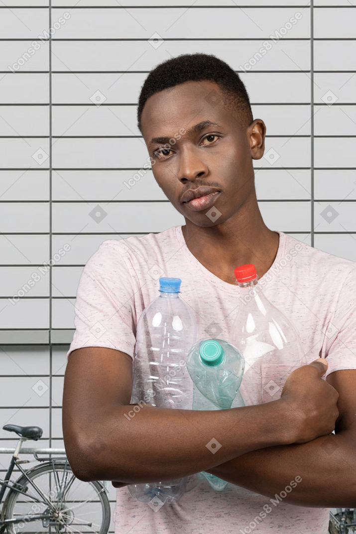 A young man standing with empty plastic bottles