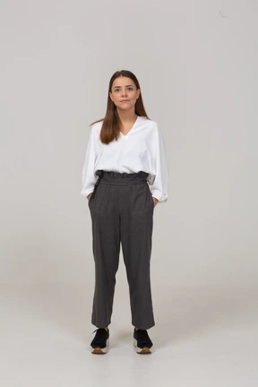 Front view of a young lady in office clothing putting hands in pockets