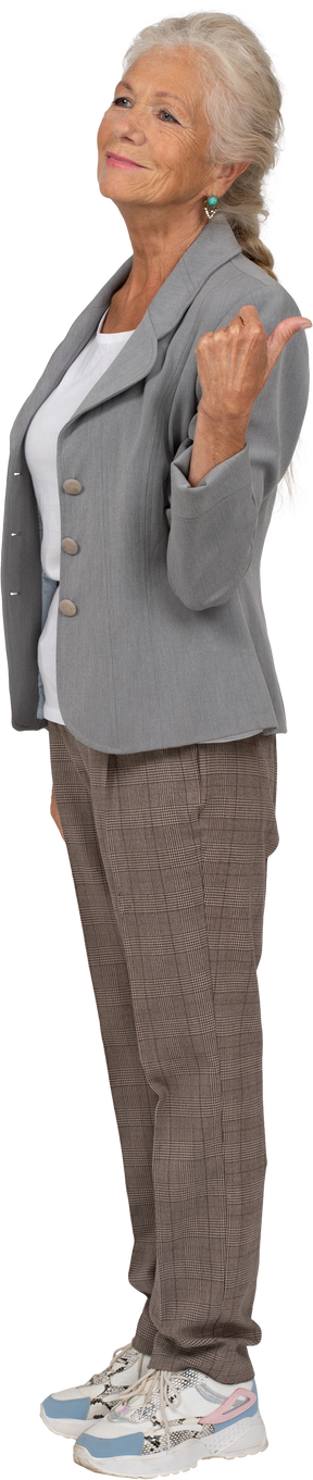 Side view of a happy old lady in suit pointing to something