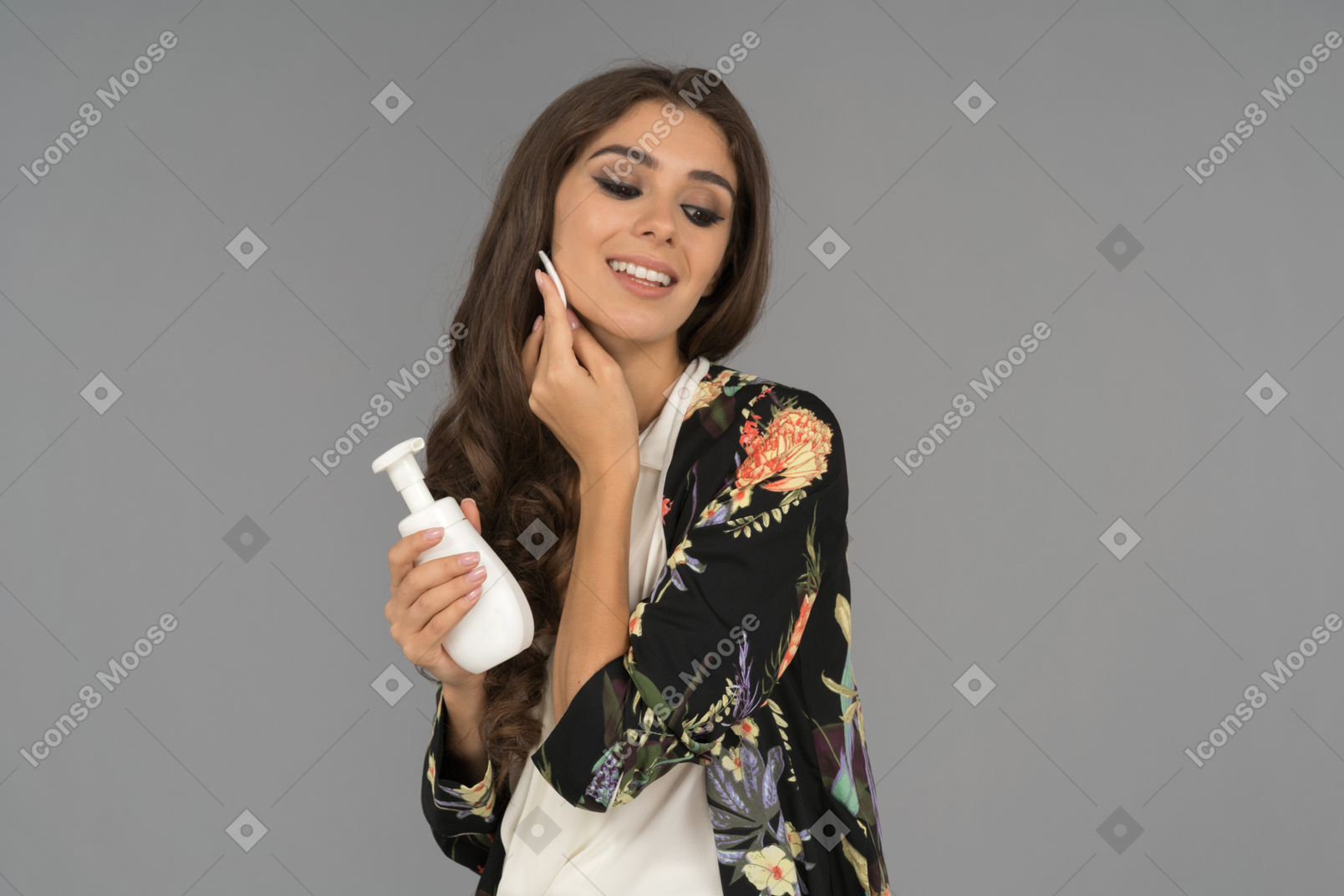 Smiling brunette woman is satisfied with a new skin care product