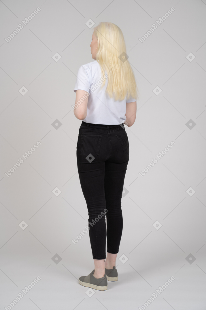 Dreiviertel-rückansicht einer jungen blonden frau in freizeitkleidung