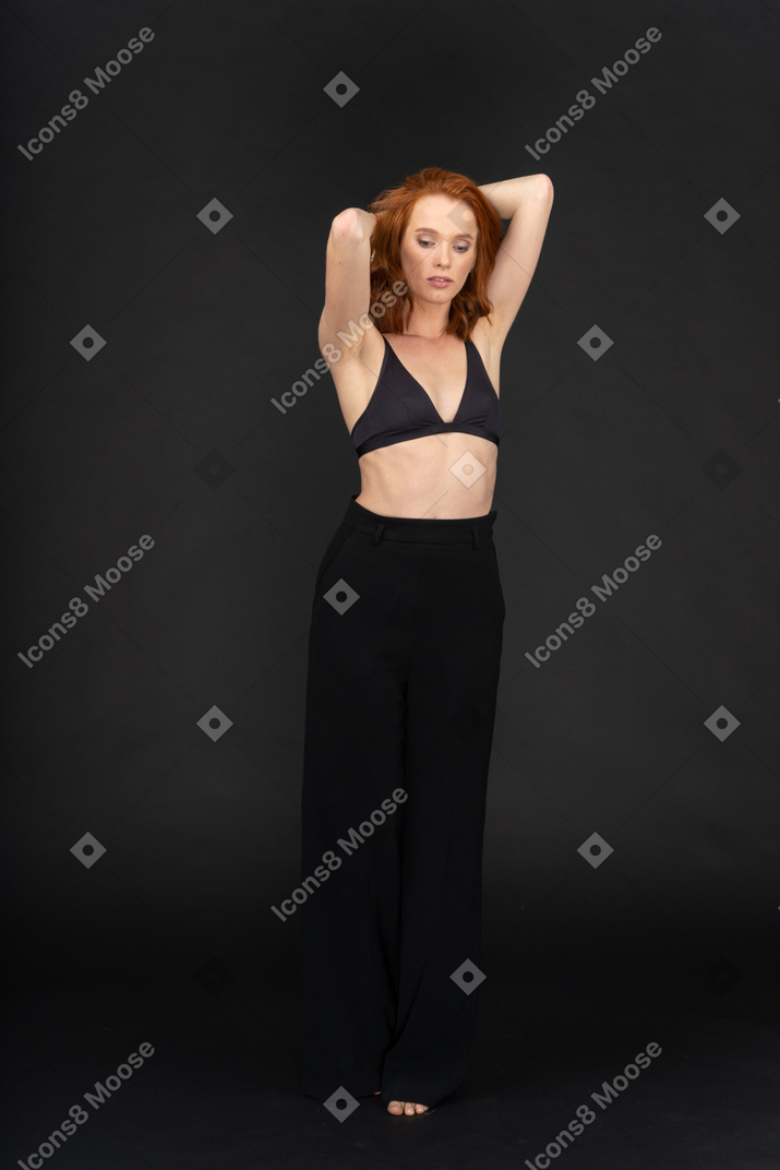 A frontal view of the young sexy woman on the black background with the eyes closed