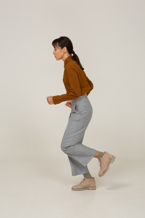 Side view of a running young asian female in breeches and blouse