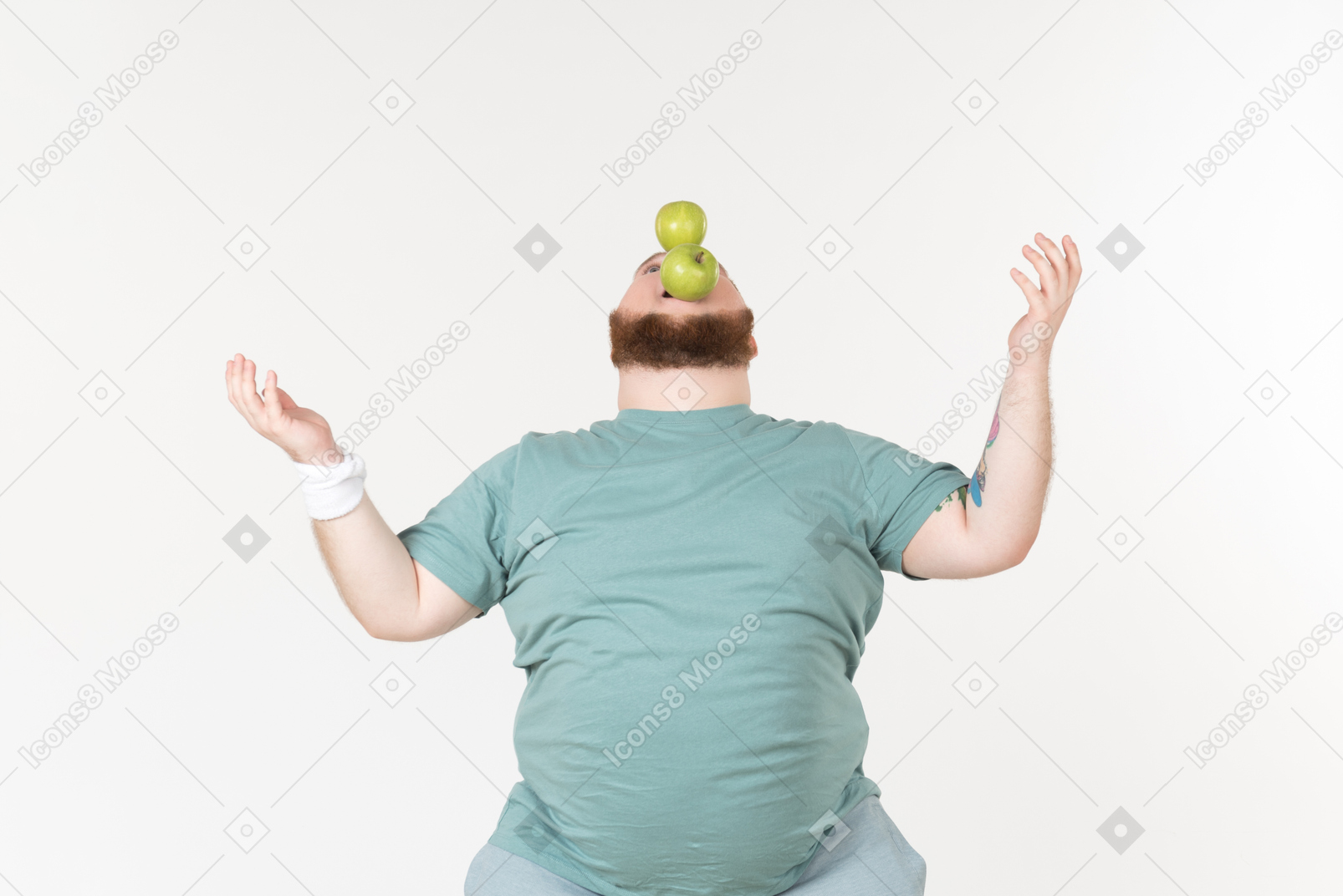 Overweight man in sportswear holding two apples in the mouth