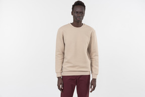 A young black man in a grey sweater standing alone on the white background