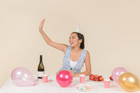 Joven mujer asiática sentada en la mesa de cumpleaños