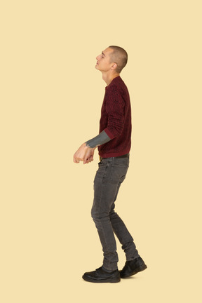 Side view of a dancing young man dressed in red pullover