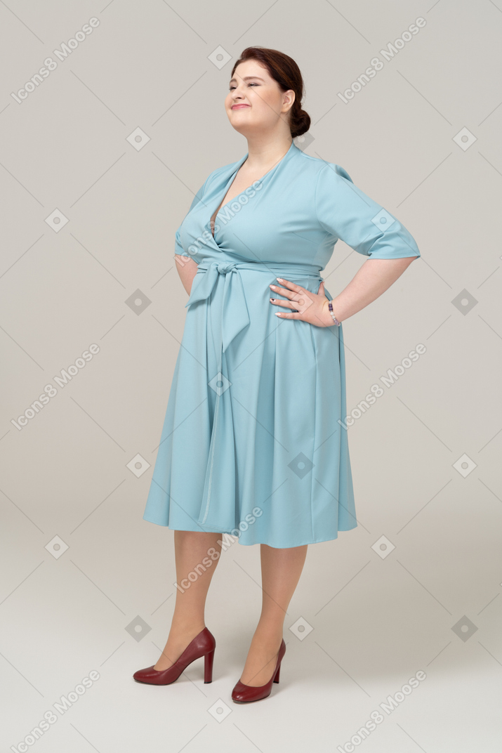 Vista frontal, de, un, mujer, en, vestido azul, posar, con, manos caderas