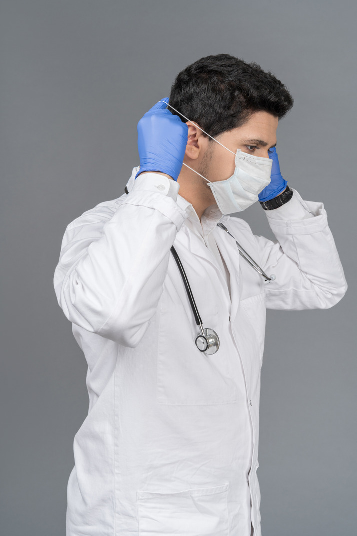Doctor putting on mask