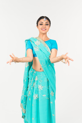 Young indian woman in blue sari standing in dance position