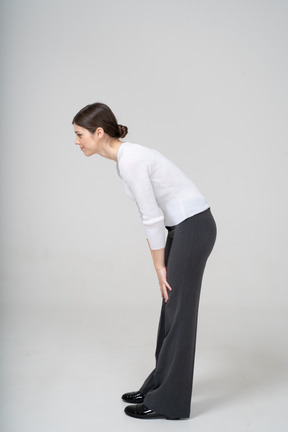 Side view of a woman in suit bending down