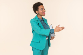 Female office worker extending hand for welcoming and holding folder