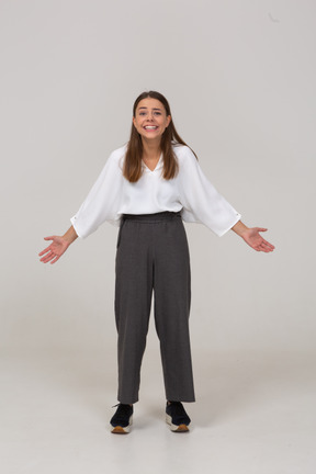 Front view of a laughing young lady in office clothing outspreading arms