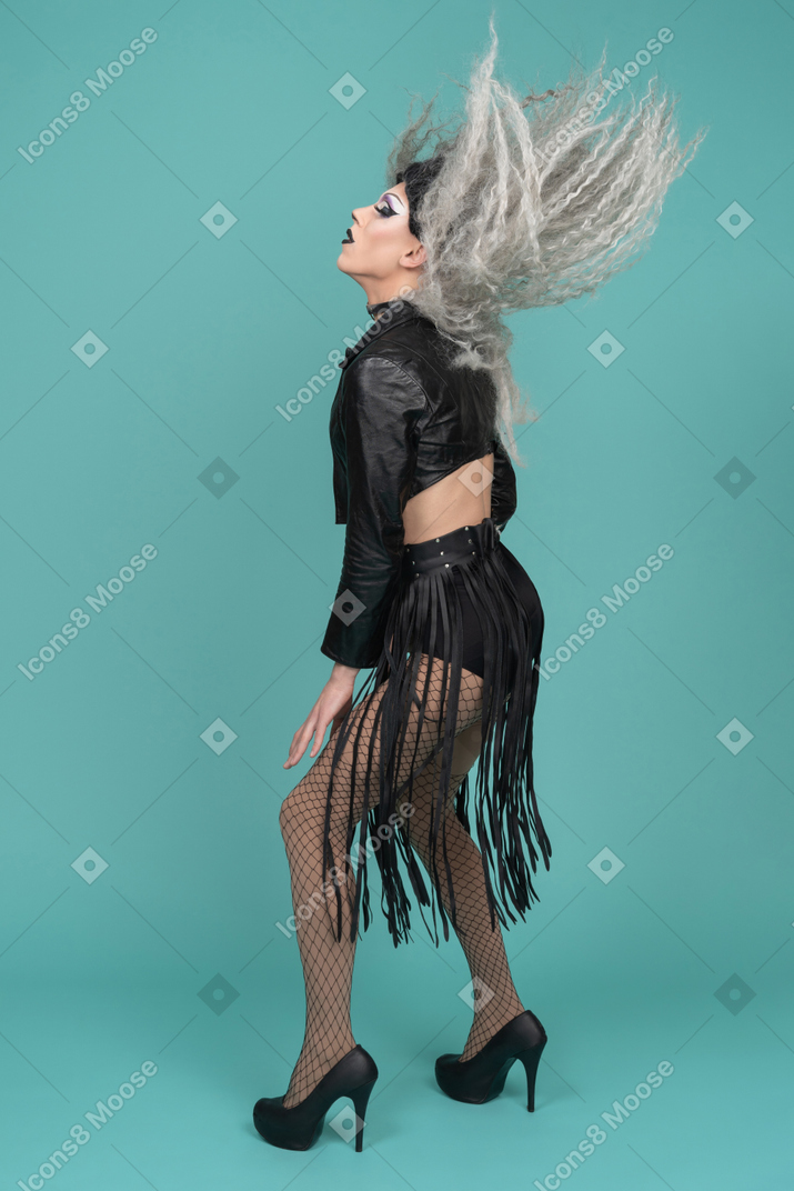 Drag queen con chaqueta de cuero sacudiéndose el pelo