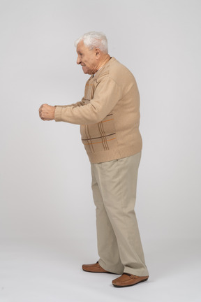 Side view of an old man in casual clothes walking