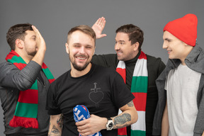 Close-up of four male football fans celebrating the victory