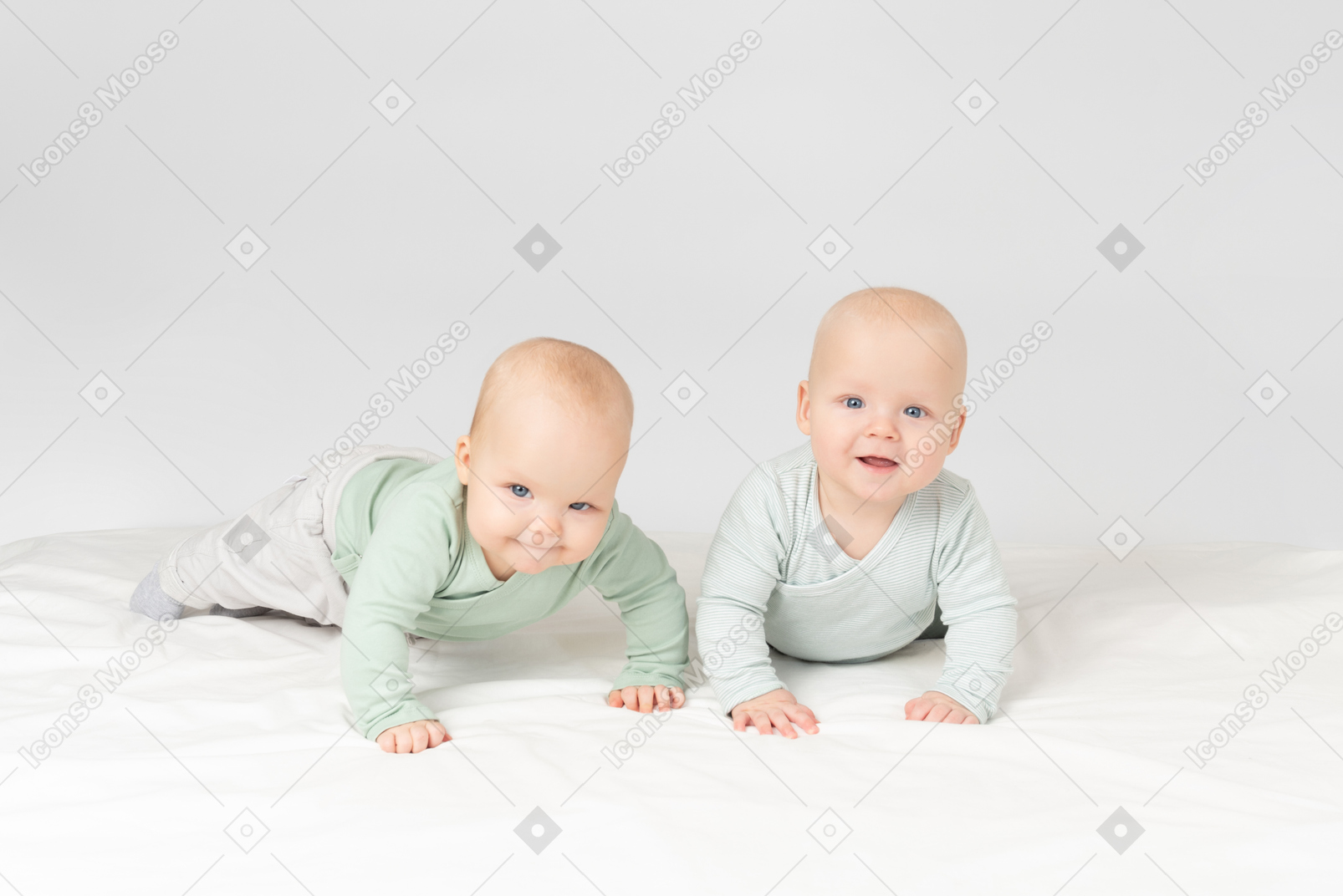 Curious babies twins lying on the stomach