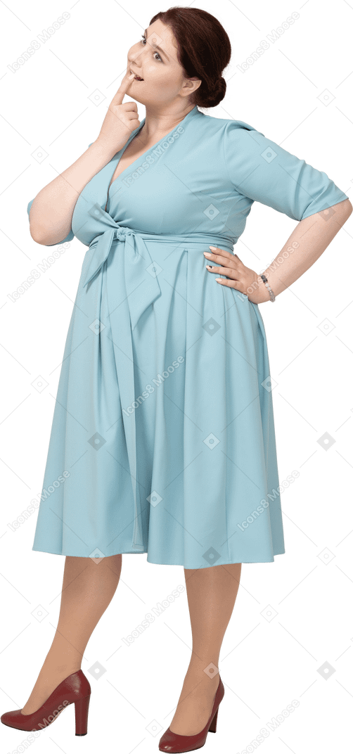 Vista laterale di una donna in abito blu che si morde il dito