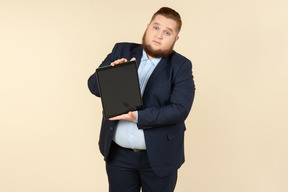 Young overweight office worker showing digital tablet