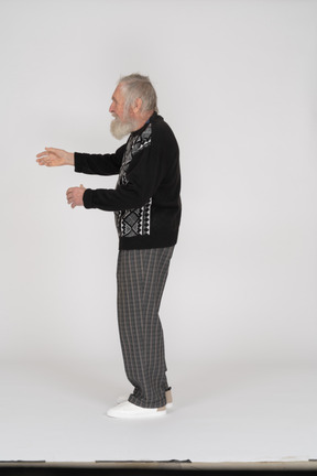 Side view of an old man gesturing with hands