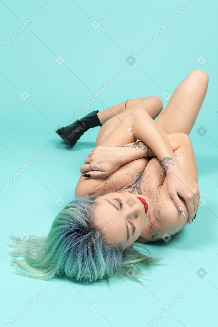 Close-up of a tattooed caucasian female over turquoise background