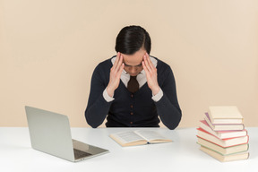 Young asian student looking upset while reading a book