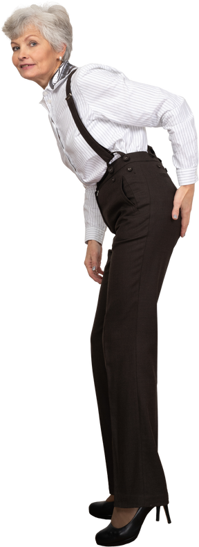Vista lateral de una anciana en ropa de oficina inclinada hacia adelante mientras toca su trasero