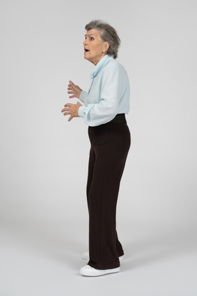 Vista laterale di una donna anziana che gesturing preoccupata