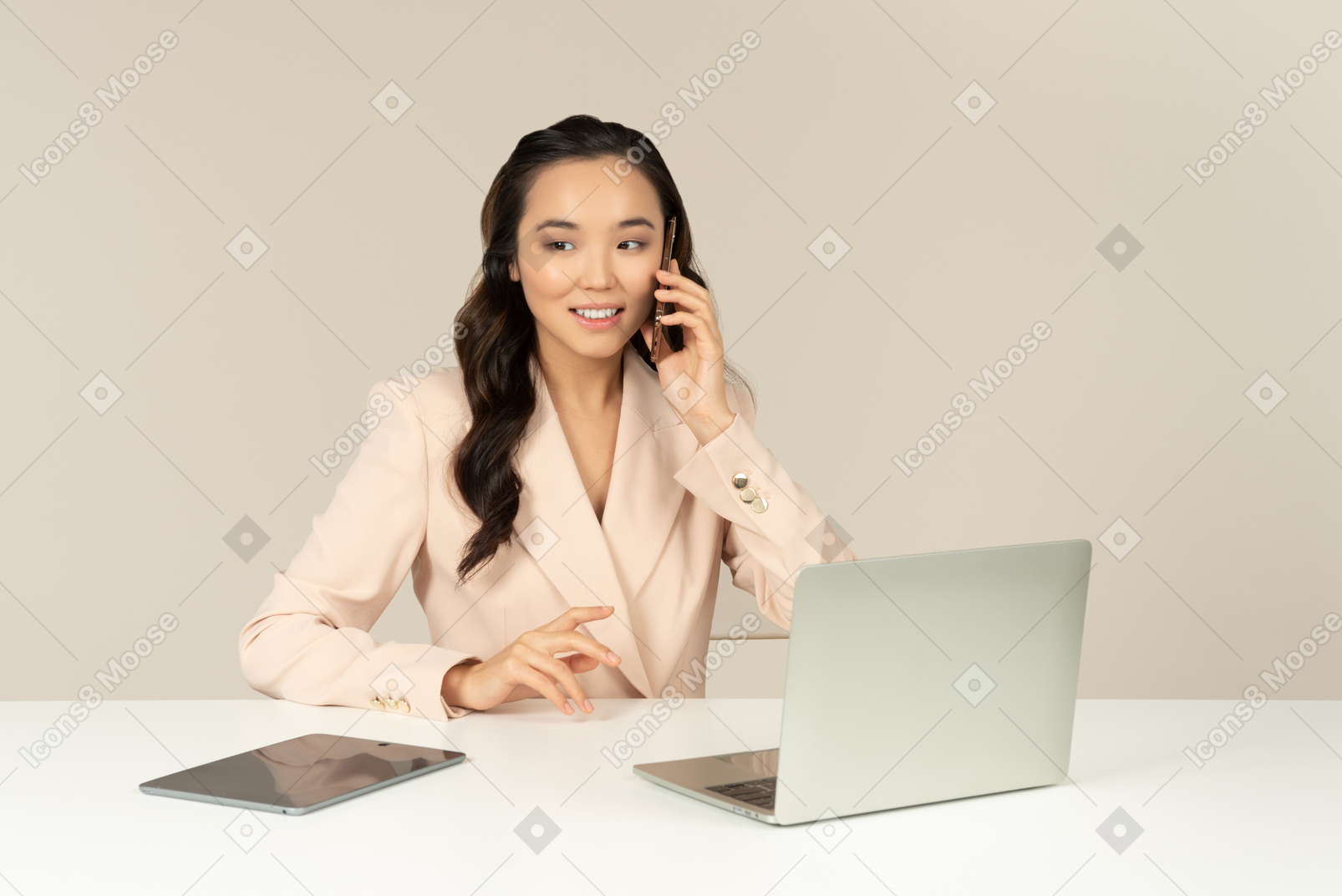 Asiatischer weiblicher büroangestellter, der am telefon spricht und an laptop arbeitet