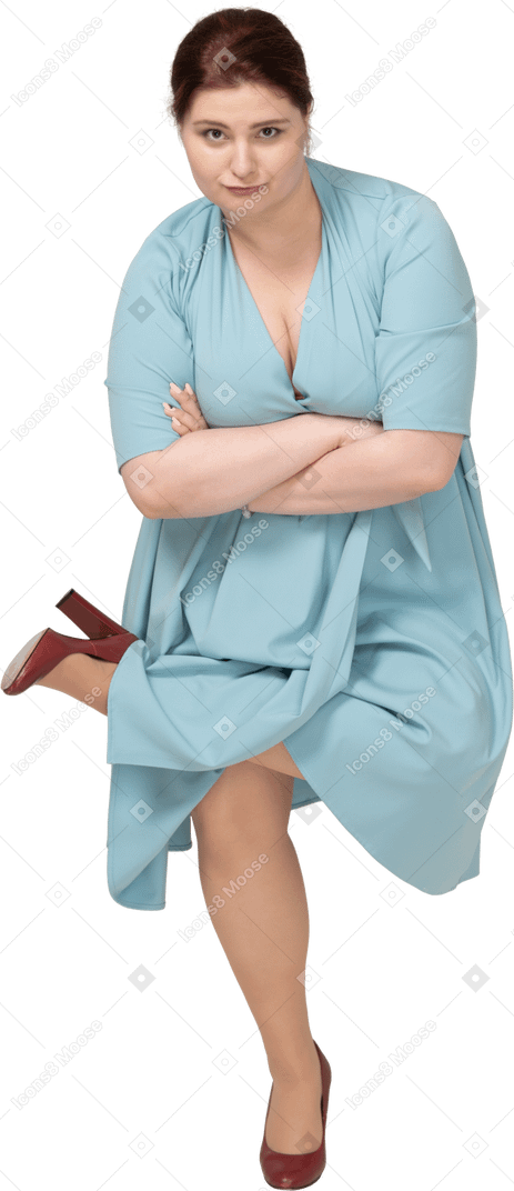 Vue de face d'une femme en robe bleue en équilibre sur une jambe