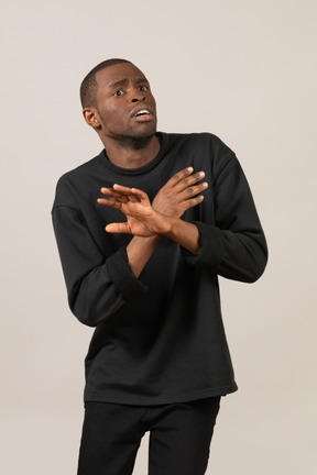 Young man looking scared with crossed arms