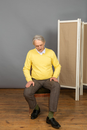 Mann mittleren alters, der von einem stuhl aufsteht