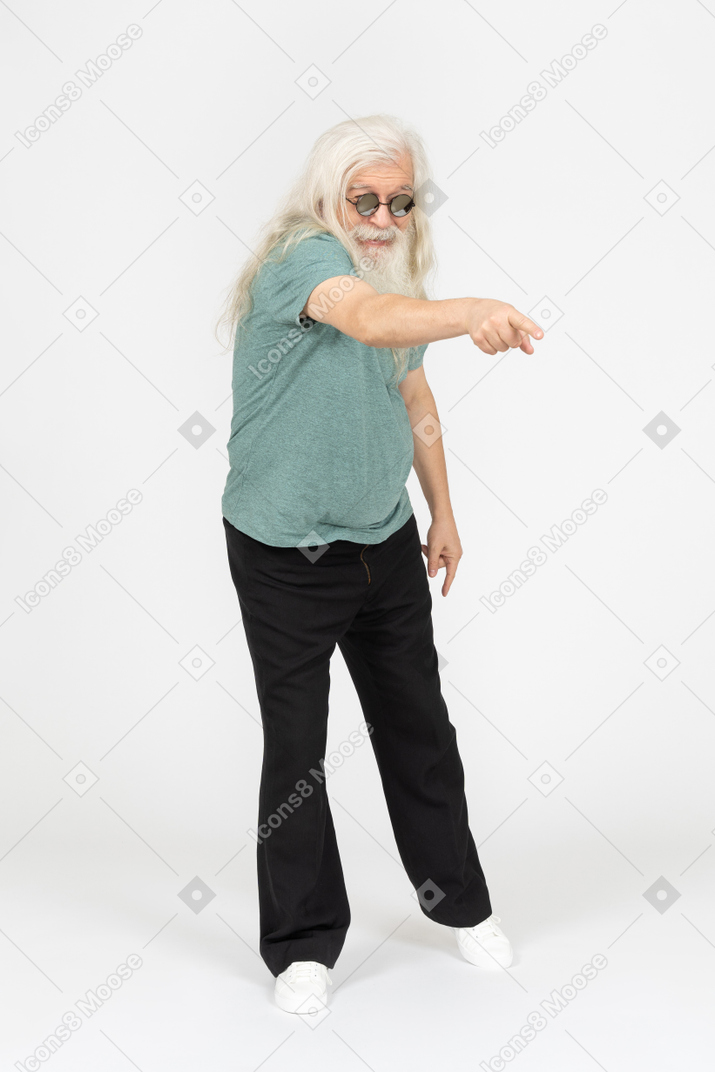 Three-quarter view of old man in sunglasses pointing at something