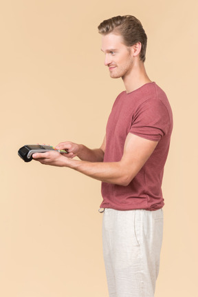 Young guy using a payment terminal