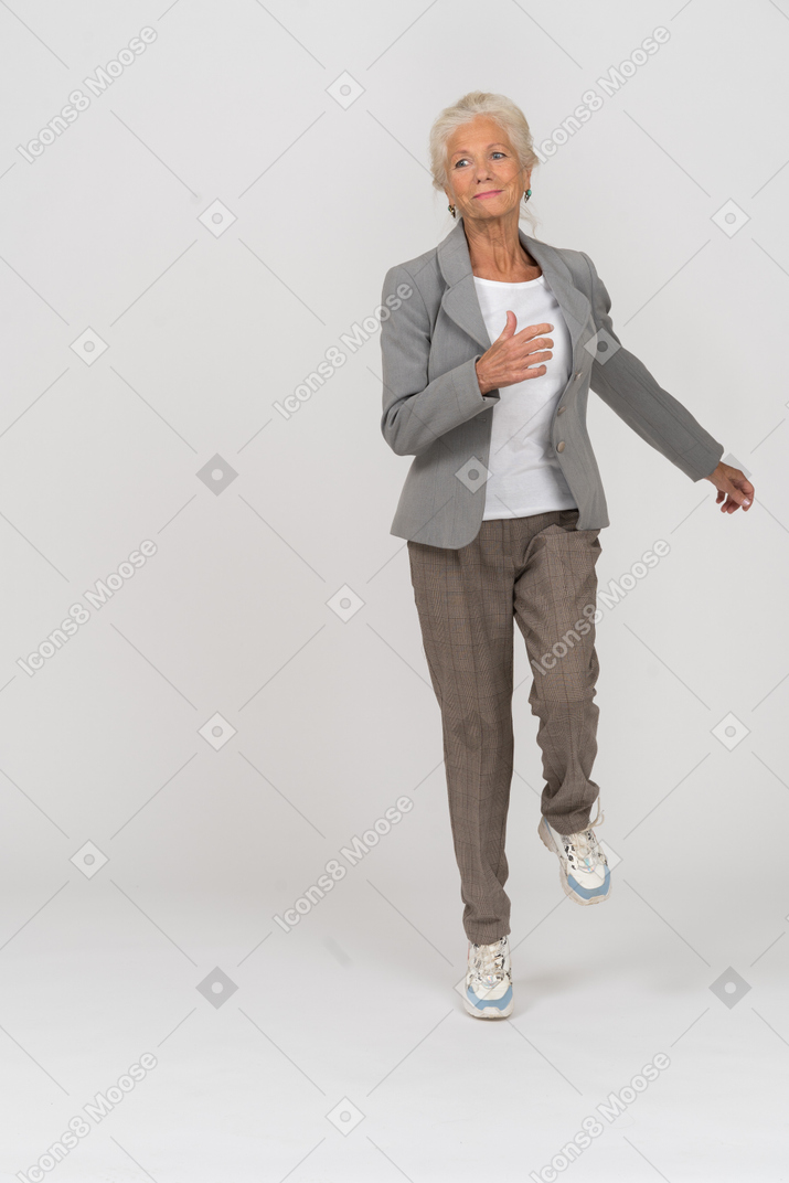 Front view of an old lady in suit walking