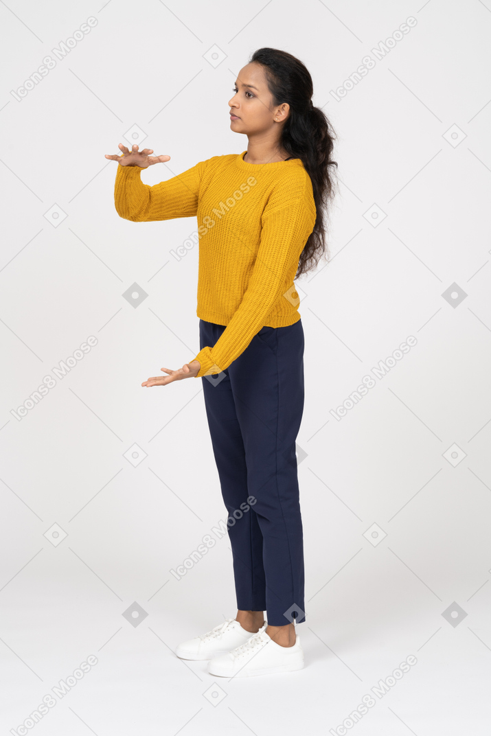Vista frontal de uma garota com roupas casuais mostrando o tamanho de algo