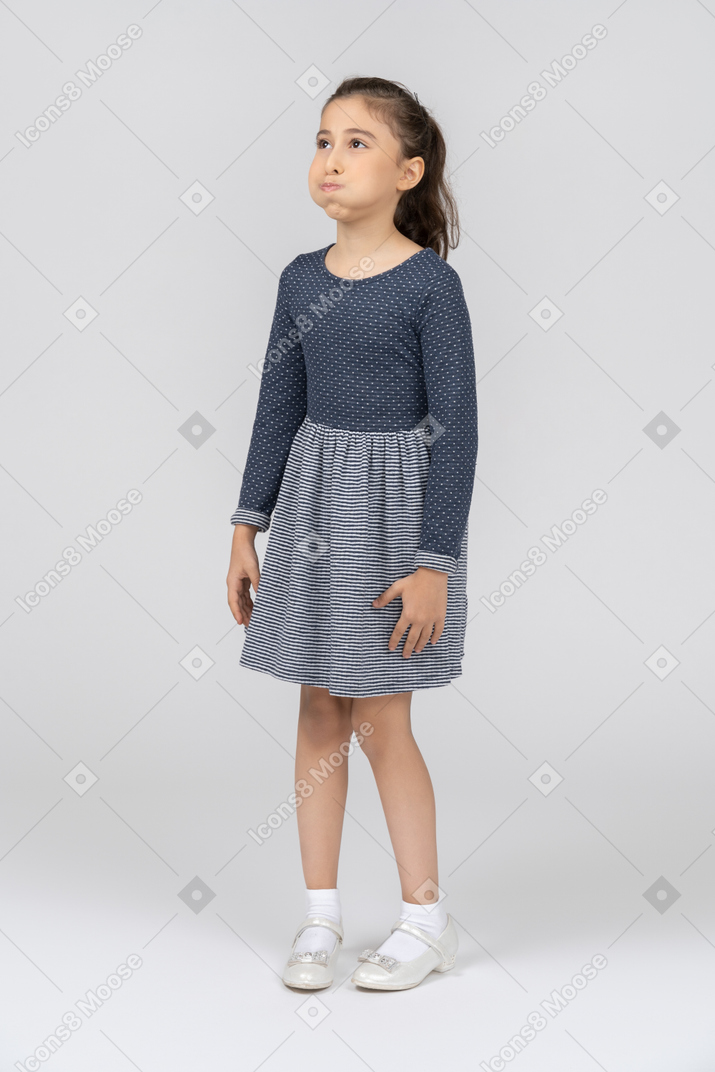 Front view of a girl in casual clothes with puffed out cheeks