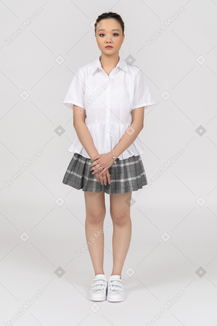Молодая азиатская девушка, стоя и держась за руки вместе