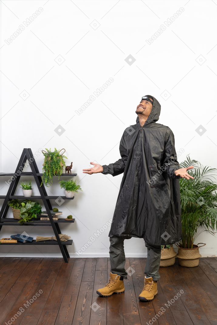 Mann im regenmantel lächelt den regen an