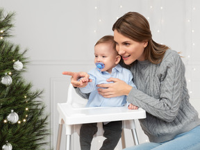 A woman holding a baby in a high chair