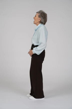 Side view of an old woman in formal clothing grimacing and gaping to the left