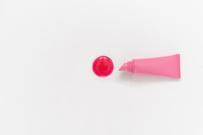 Lápiz labial rosa y gota de lápiz labial sobre fondo blanco.
