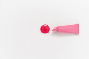 Pink lipstick and drop of lipstick on white background