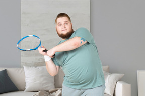 A man with a beard holding a tennis racket