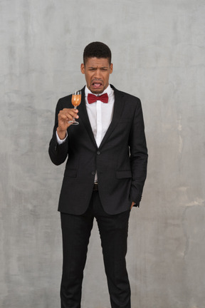 Young man with a glass of champagne experiencing nausea